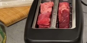 Una donna cucina una bistecca in un tostapane