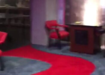 La donna tira una leva nascosta e il suo camino si sposta per rivelare una sala segreta